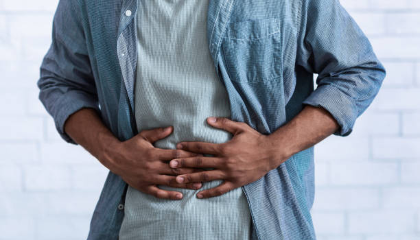 Natural Gut Inflammation. Person holding their stomach, indicating discomfort or pain, potentially related to gut inflammation.